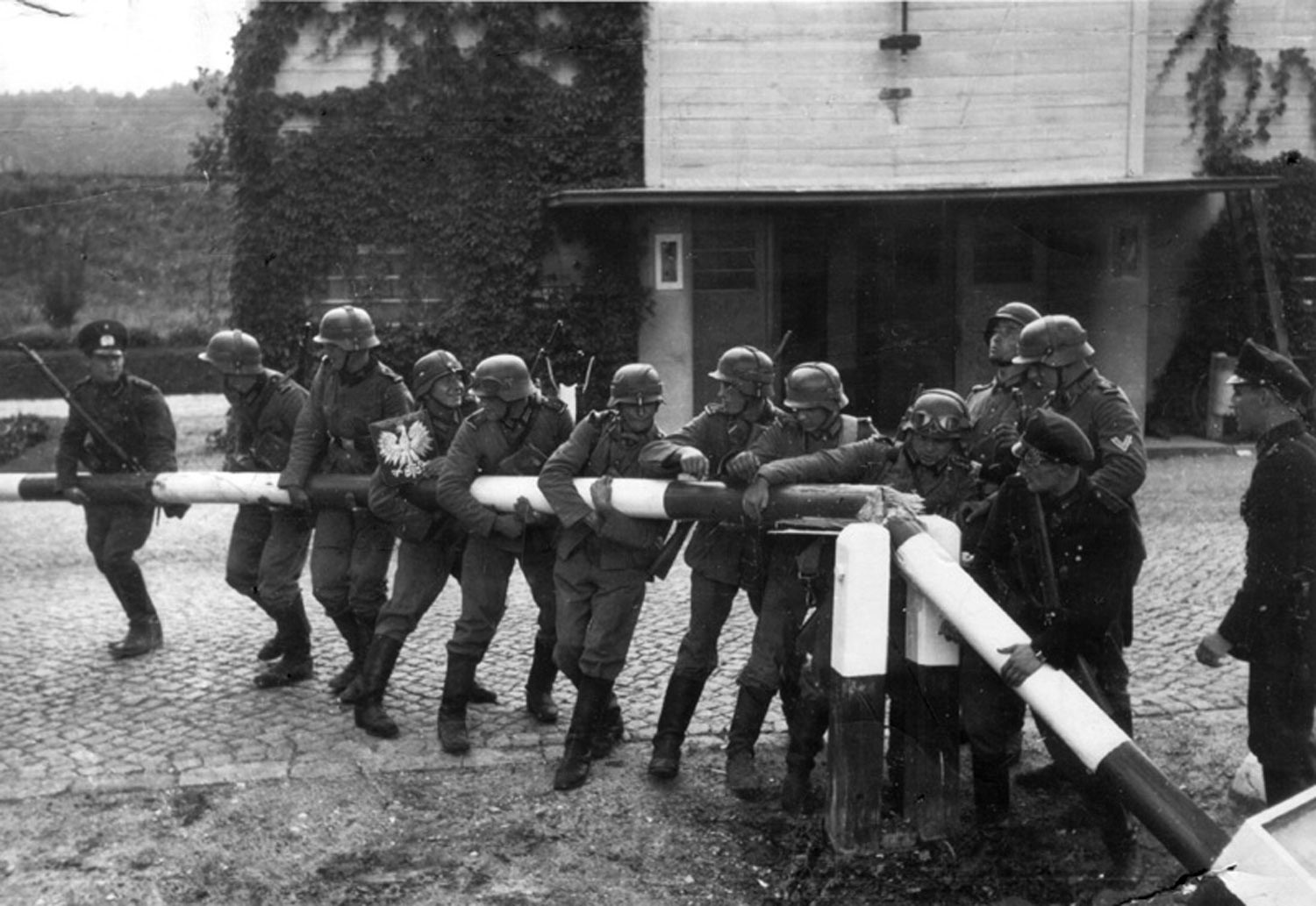 Polizisten und Grenzbeamte aus Danzig (heute polnisch Gdańsk) stellen die Zerstörung eines polnischen Schlagbaums nach. Polizisten und Grenzbeamte aus Danzig (heute polnisch Gdańsk) stellen die Zerstörung eines polnischen Schlagbaums nach.
