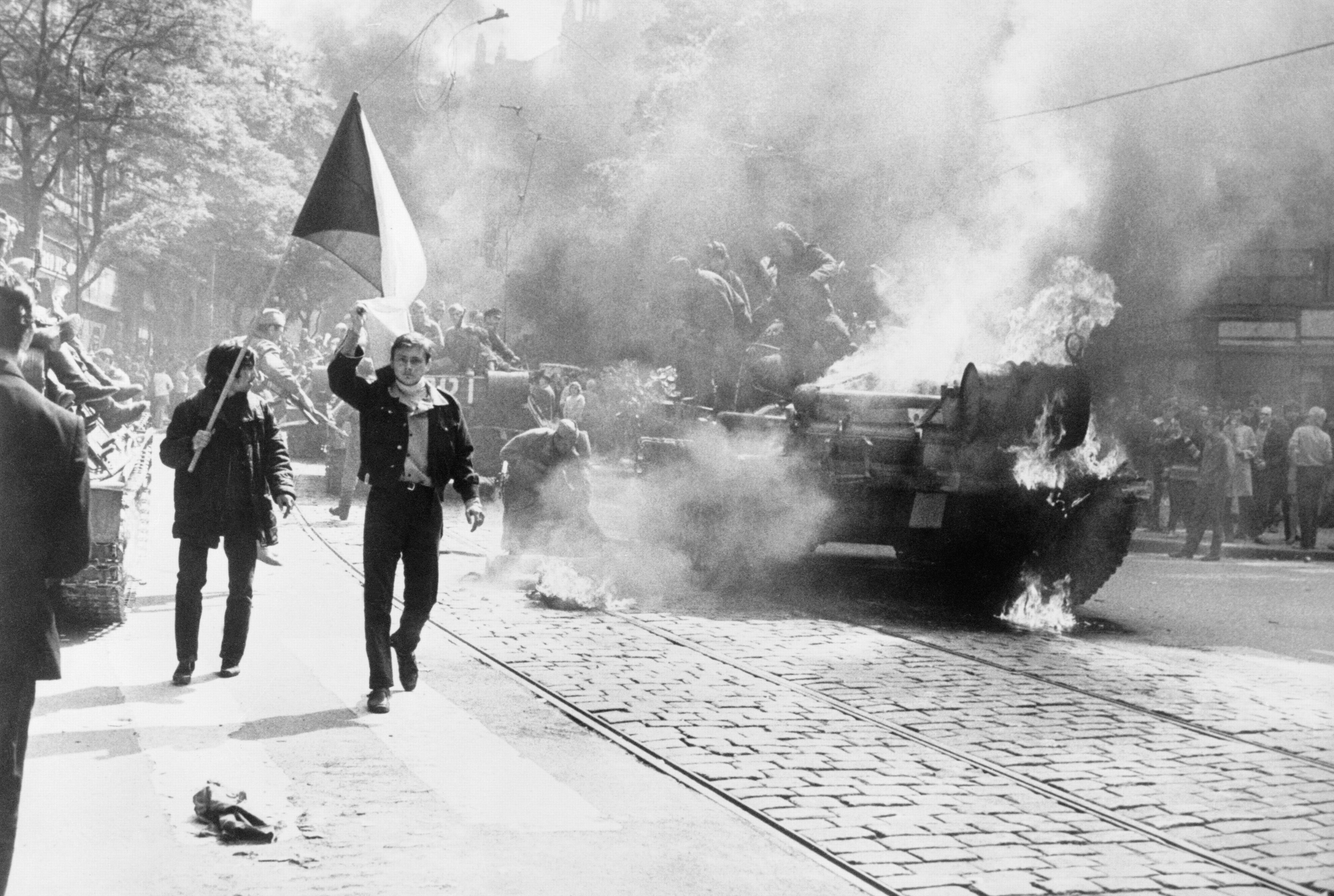 Prag, 21.– 23. August 1968: Einwohner mit tschechoslowakischer Flagge vor einem brennenden sowjetischen Panzer während der gewaltsamen Niederschlagung des »Prager Frühlings« durch Truppen des Warschauer Vertrages. Prag, 21.– 23. August 1968: Einwohner mit tschechoslowakischer Flagge vor einem brennenden sowjetischen Panzer während der gewaltsamen Niederschlagung des »Prager Frühlings« durch Truppen des Warschauer Vertrages.