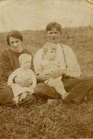Auf diesem Bild sind Truus’ Mutter und Vater zu sehen. Die Mutter hat die neun Monate alte Truus auf dem Schoß. Der Junge, den der Vater hält, ist vermutlich ein Nachbarskind.