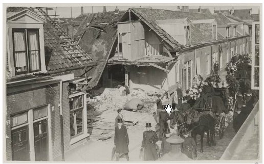 Durch die Bombenangriffe der deutschen Wehrmacht wurden viele niederländische Städte zerstört. Hier sieht man ein von einer Bombe zerstörtes Haus in Haarlem im Jahr 1941. Rechts daneben sieht man einen Trauerumzug für die Opfer der Bombardierung.